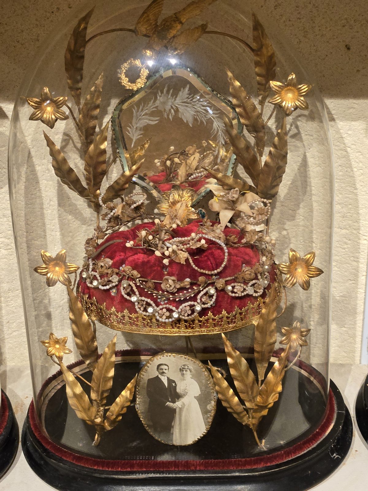 A bridal headdress featuring a red jeweled centerpiece with gold filigree