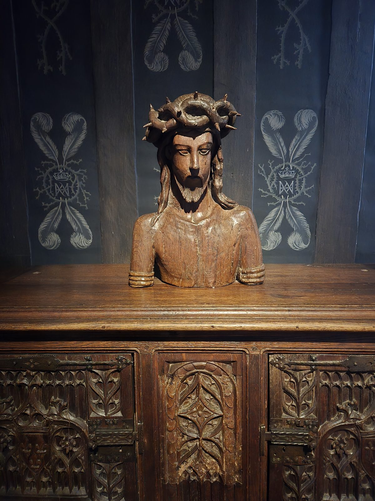 An ornately carved wooden chest featuring a figure of Christ