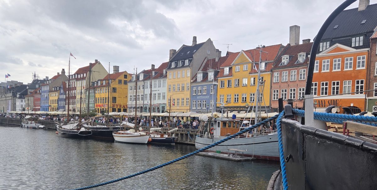 Nyhavn harbor with colorful buildings, sailboats, and a Danish flag