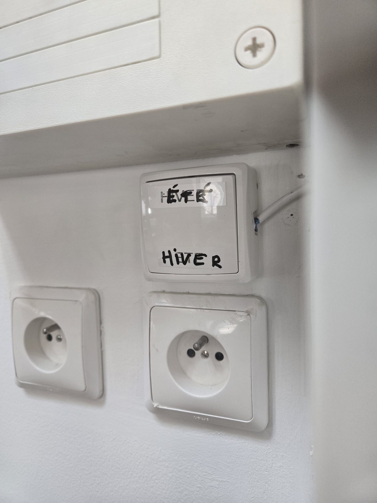 A wall switch labeled été and hiver — summer and winter