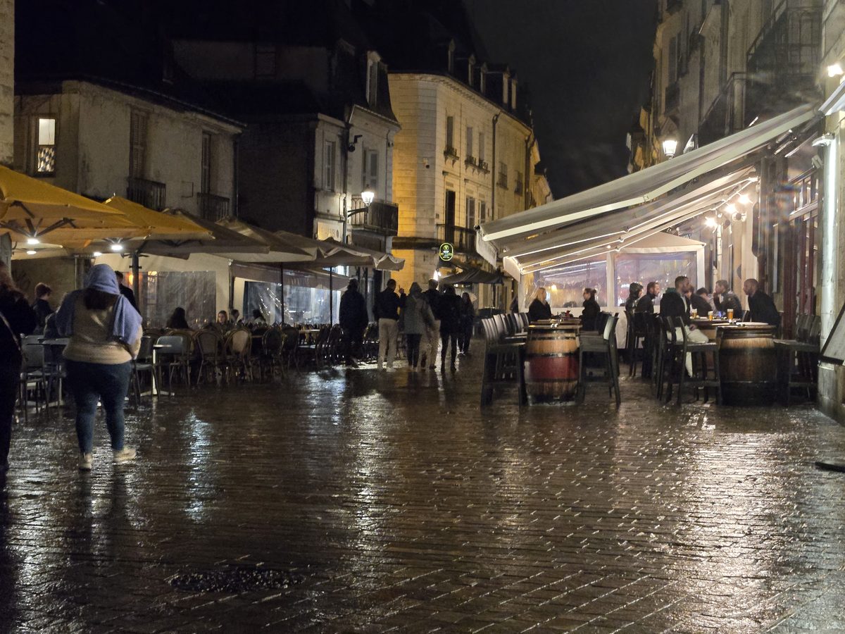 Tours old town at night — warm light on wet cobblestones