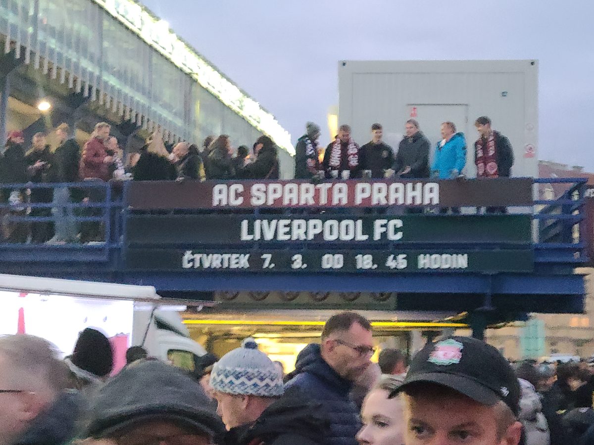 Fans gathering outside the stadium with the AC Sparta Praha vs Liverpool FC match board